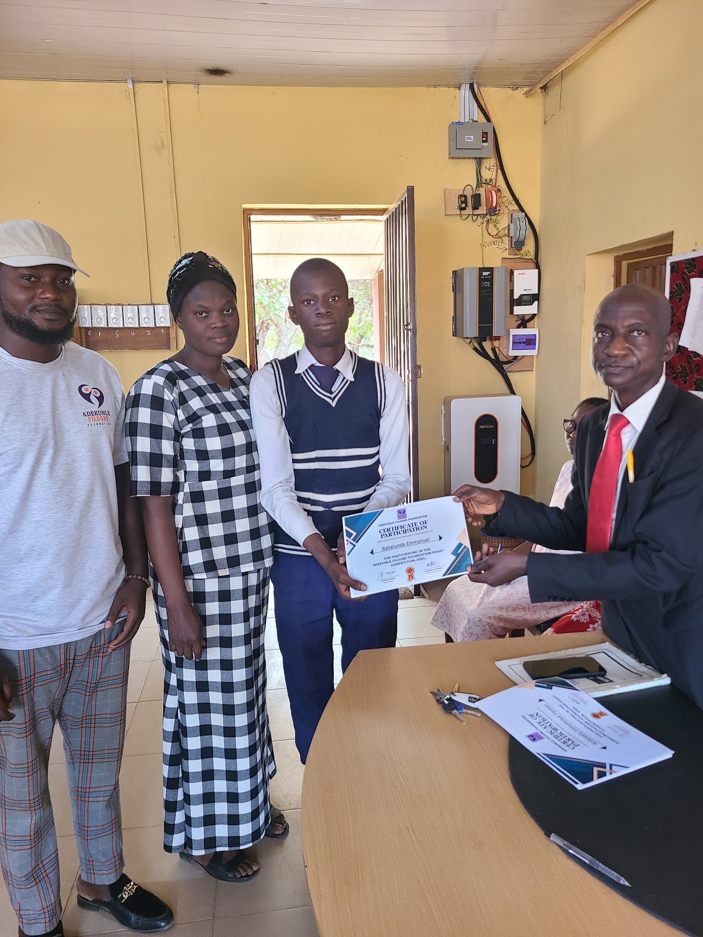 A student holding a certificate with foundation volunteers.